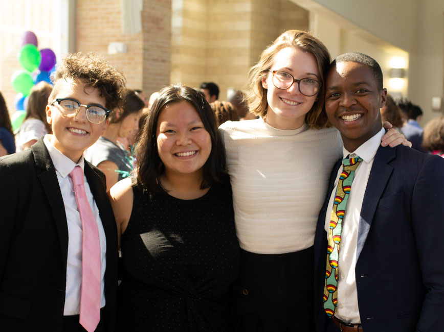 Group of four Scholars standing and smiling Group of four Scholars standing and smiling