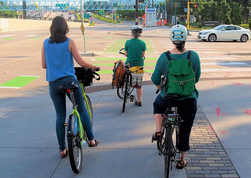Three bicyclists waiting at red light