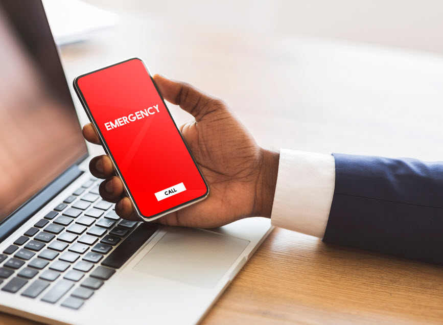 Person holding a phone with notification of emergency.